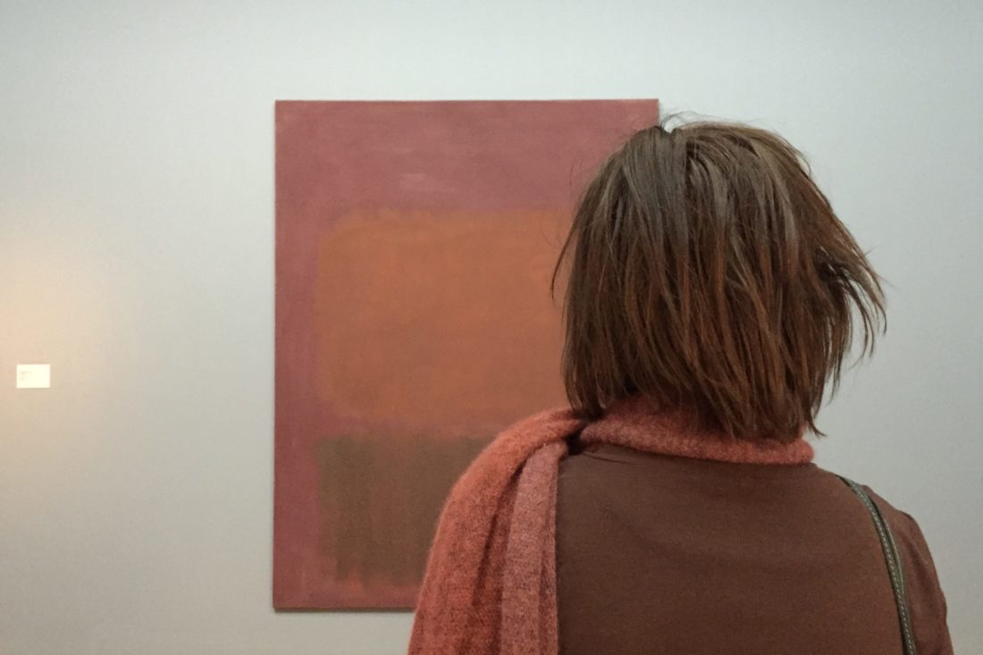 Eine Museumsbesucherin betrachtet ein Bild von Mark Rothko